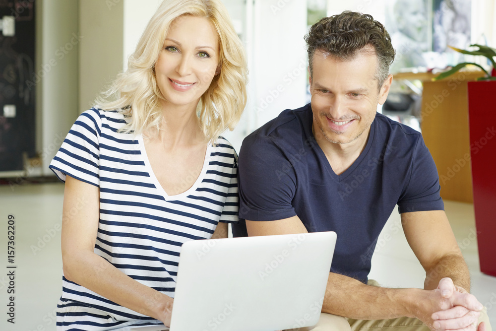 Browsing together. Shot of a happy mature couple relaxing on the couch using a laptop. Browsing together. Shot of a happy mature couple relaxing on the couch using a laptop.