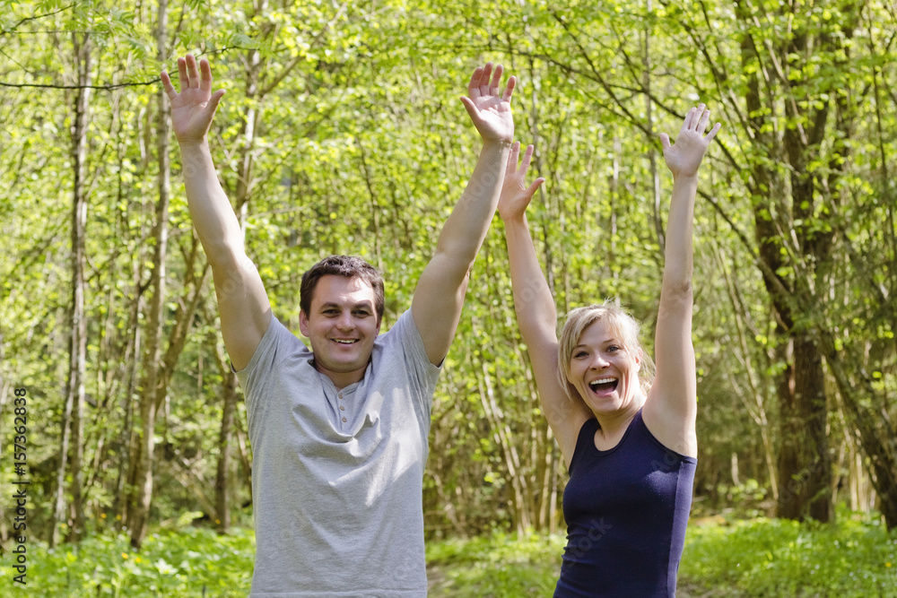 Happy joyful couple is happy in the park in hand raises his hands up,victory,win,bright colored