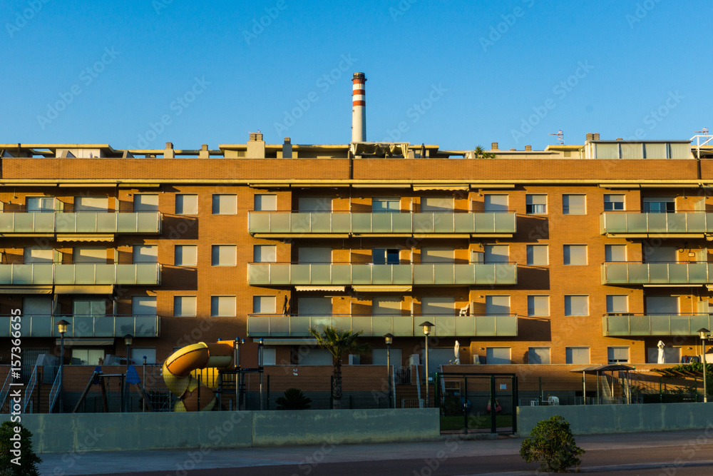 Fototapeta premium Housing at sunset with factory behind