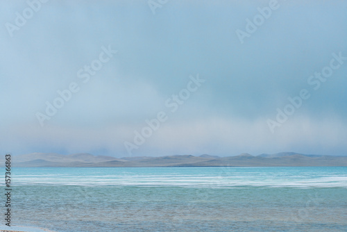 panoramic view of lake at cloudy day with great mountains on background 