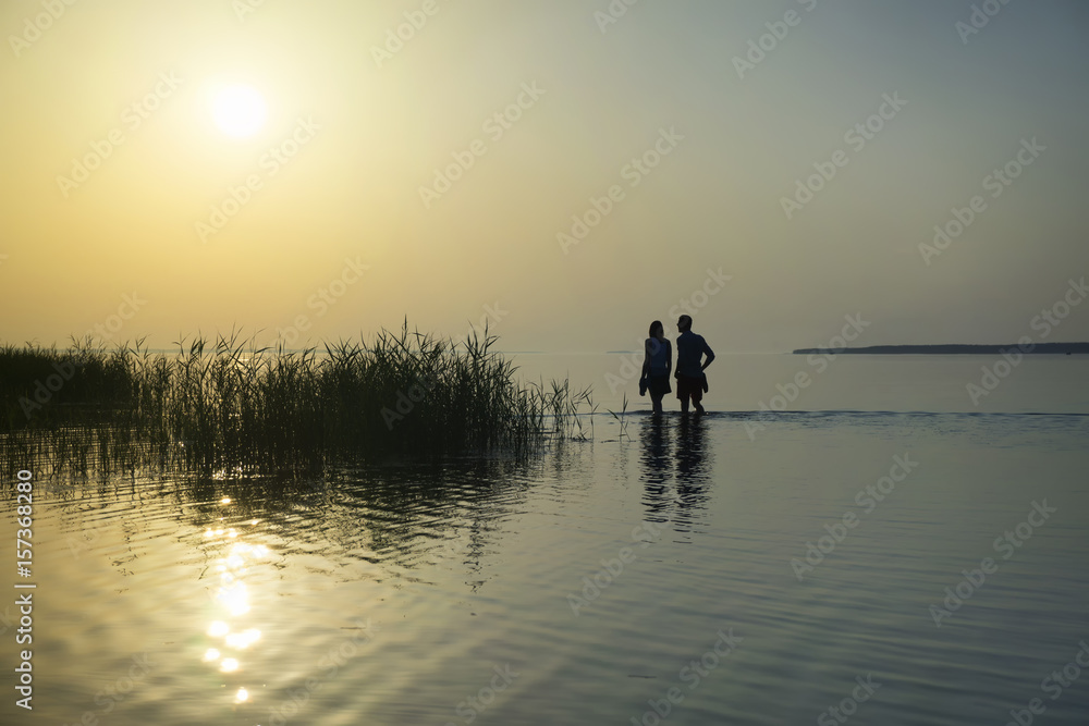 sunset and man with woman on the beach