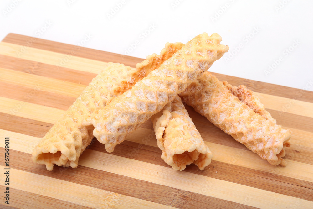 Homemade wafer rolls with powdered sugar isolated on white background Homemade wafer rolls with powdered sugar isolated on white background