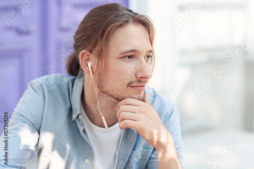Handsome young man listenin...