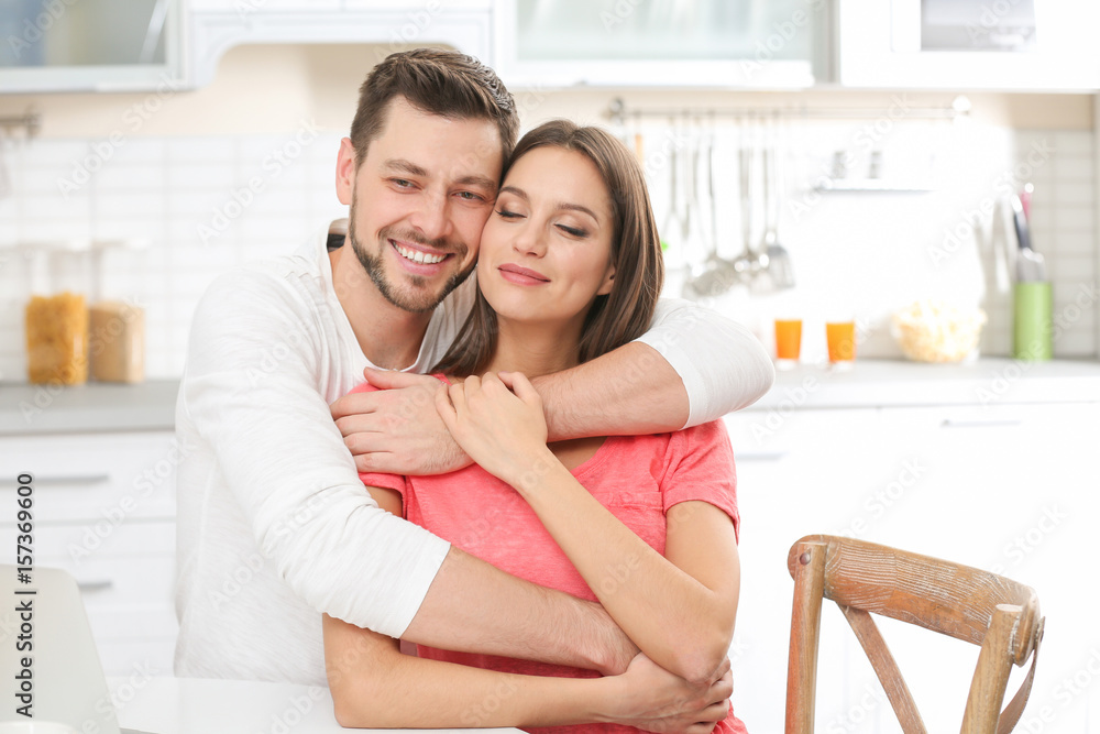 Young couple embracing at kitchen Young couple embracing at kitchen