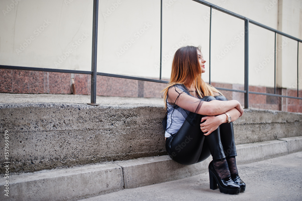 Fashionable woman look at white shirt, black transparent clothes, leather pants, posing at street against iron railings. Concept of fashion girl. Fashionable woman look at white shirt, black transparent clothes, leather pants, posing at street against iron railings. Concept of fashion girl.