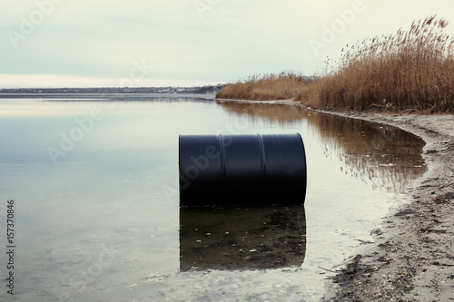 Big black barrel on beach. Environment pollution concept