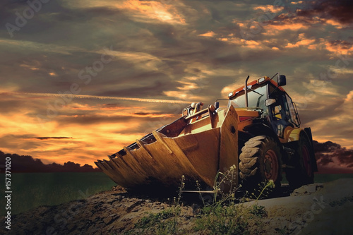 Yellow tractor on sky background