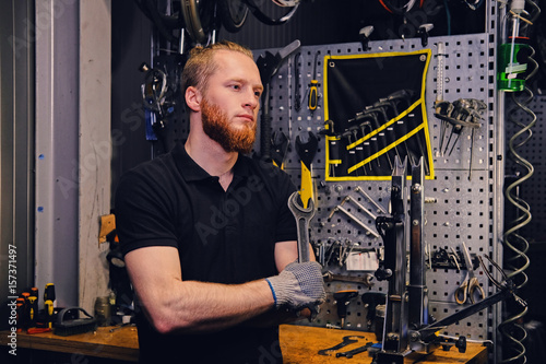 Bicycle mechanic over tool stand background in a workshop. © Fxquadro