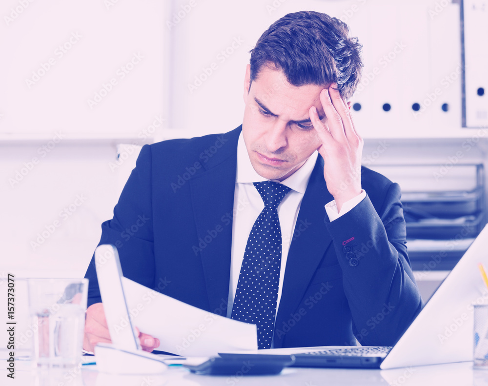 Naklejka premium Worried manager working in office