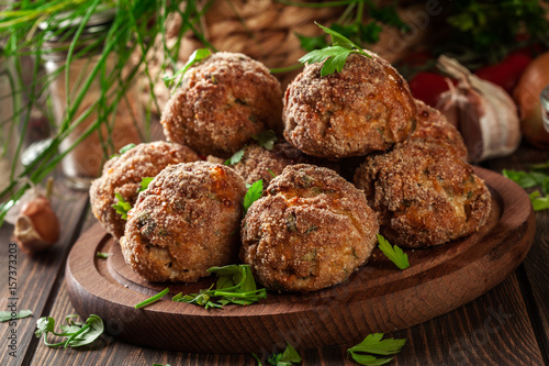 Stack of baked meatballs on a chopping board