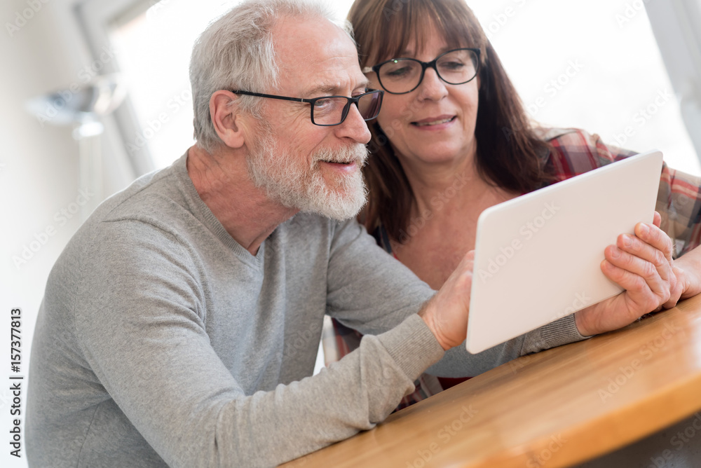 Modern mature couple using tablet