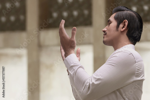 Religious asian muslim man in traditional dress praying