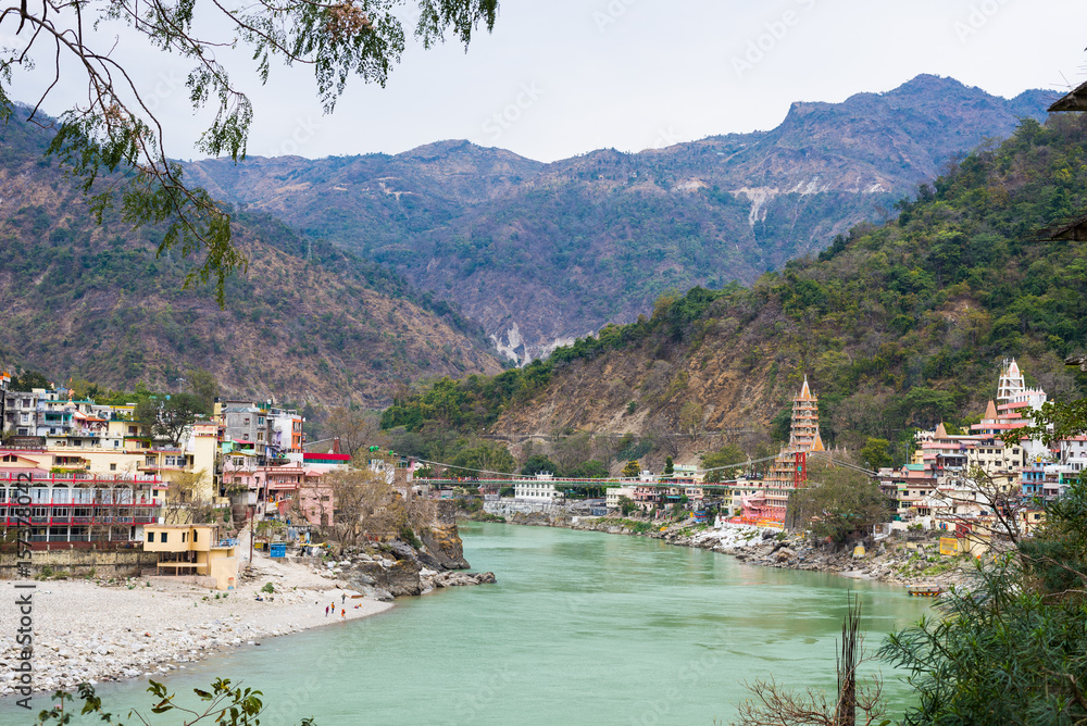 Rishikesh, holy town and travel destination in India. The Ganges River flowing between mountain from the Himalayas