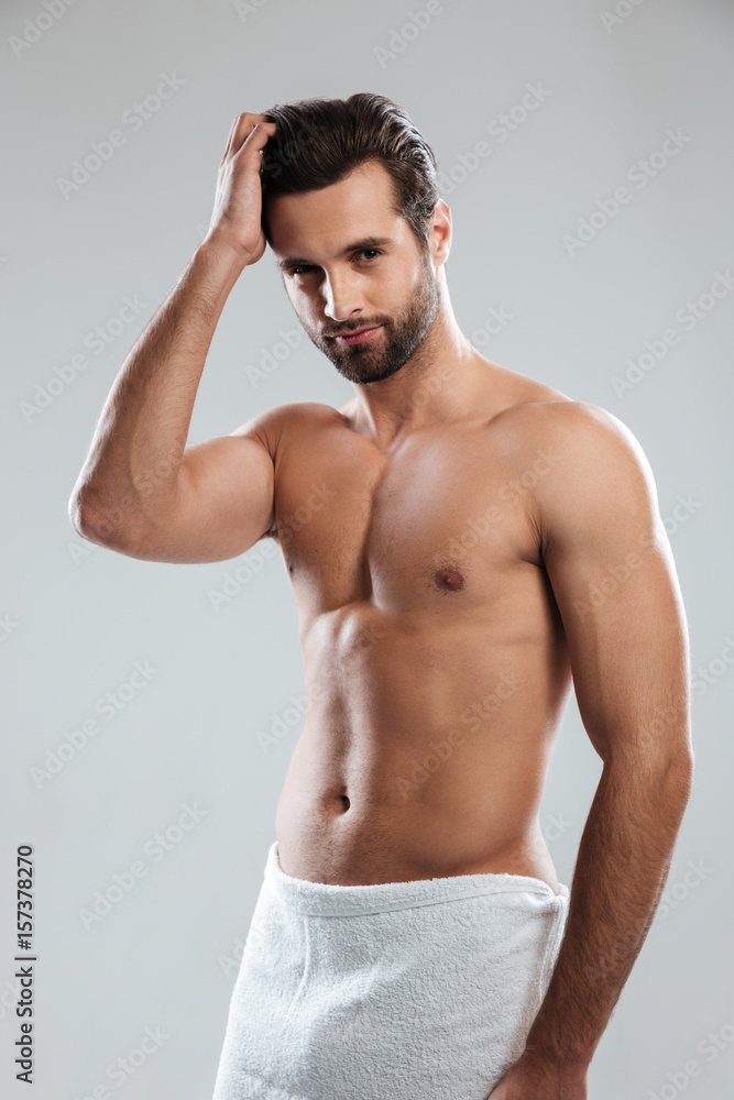 Fototapeta premium Concentrated young man dressed in towel