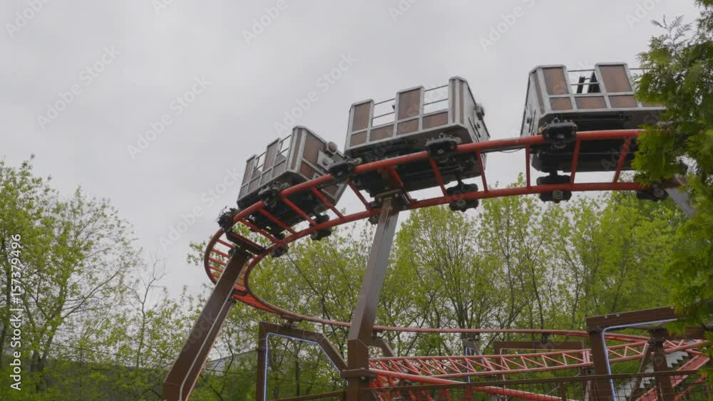 Children go in roller coaster and having fun on a cloudy day, Moscow. UltraHD stock footage.