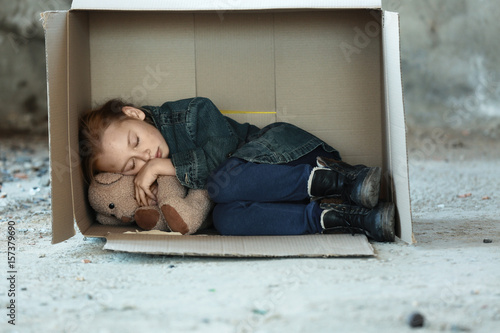 Obraz na plátně Poor little girl sleeping in cardboard box on street