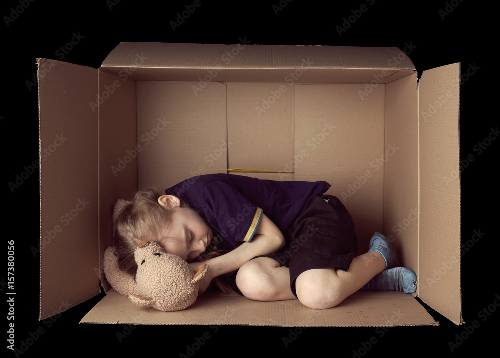 Poor little girl sleeping in cardboard box on black background Stock Photo  | Adobe Stock