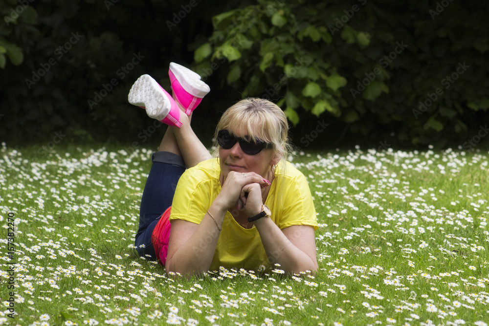 Fototapeta premium 45 years old beautiful woman lying on the ground in nature