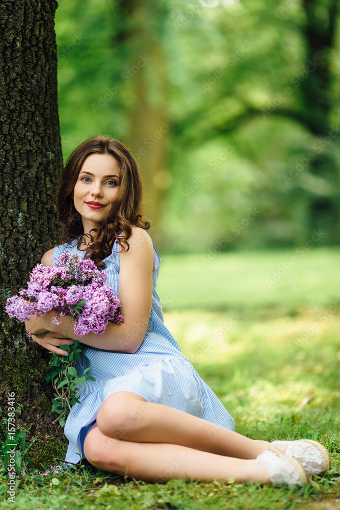 Young girl stand at park background with bouquet of flowers Young girl stand at park background with bouquet of flowers