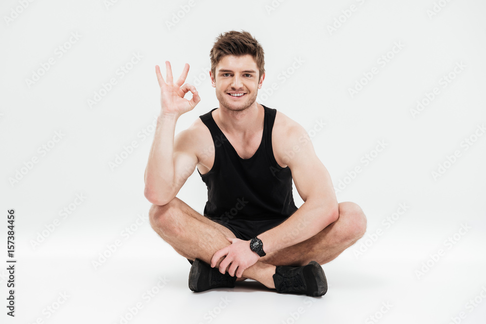 Portrait of a young smiling healthy fitness man sitting Portrait of a young smiling healthy fitness man sitting