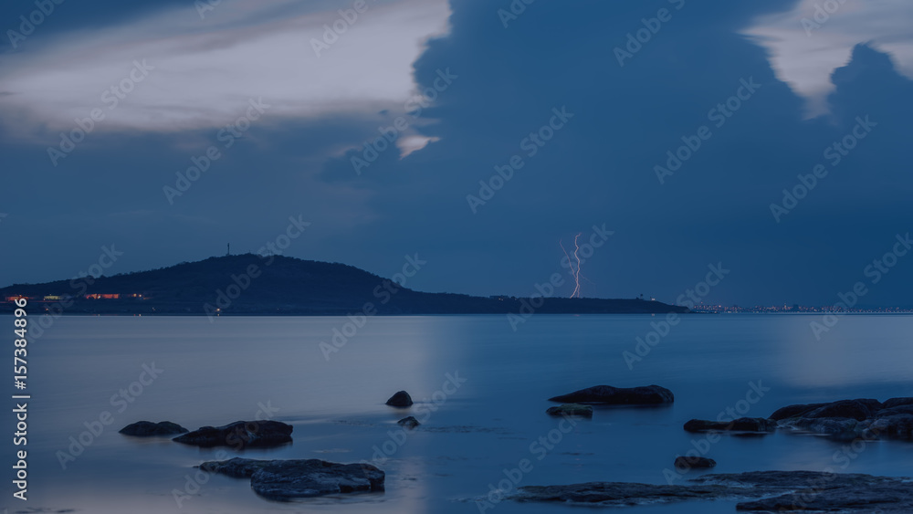 Dramatic nature background - thunders in dark sky over the sea