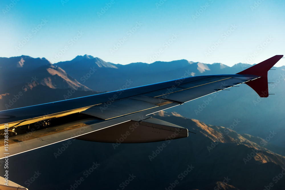 Obraz premium View from airplane window. Wing of an airplane flying above the clouds.