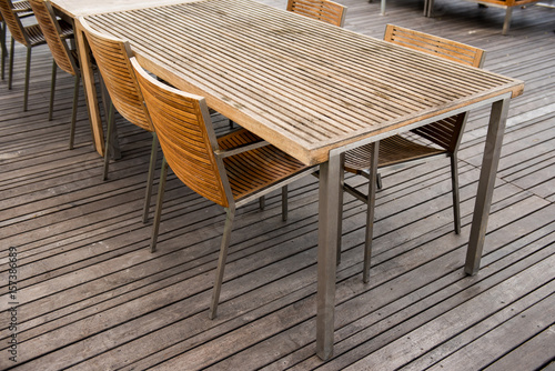 corner of wood table and chair set on wooden plank floor in outdoor restaurant. Close up
