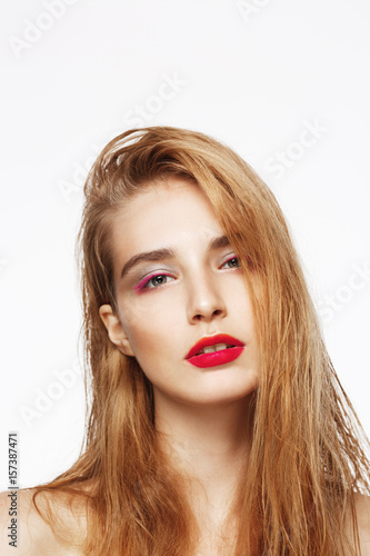 Close-up portrait of young beautiful sad confident girl with bright make up. White background. Isolated.