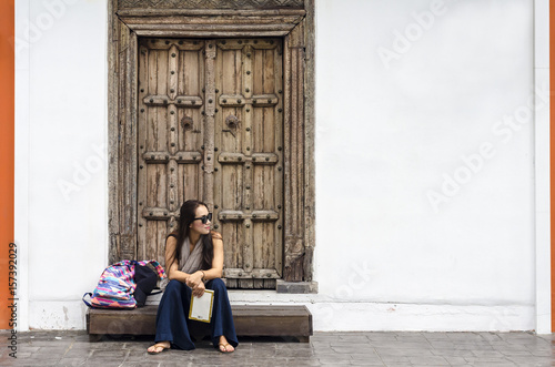 Travel guide. Young female traveler with backpack.
