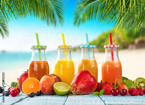 Fresh smoothie drinks placed on wooden planks, blur beach on background