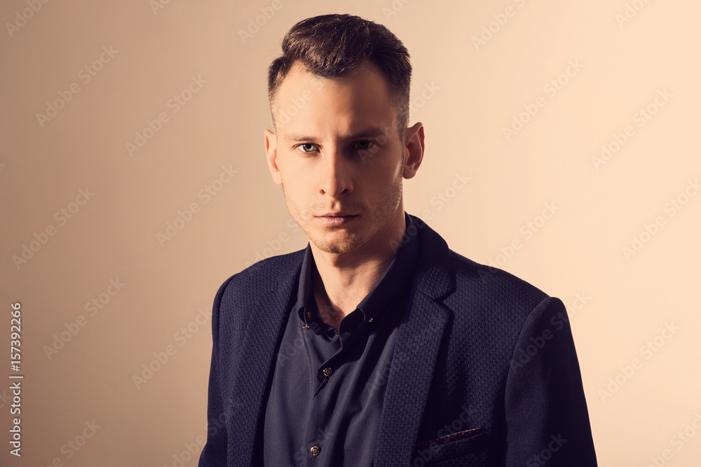 Obraz premium businessman with crossed arms pose against beige background