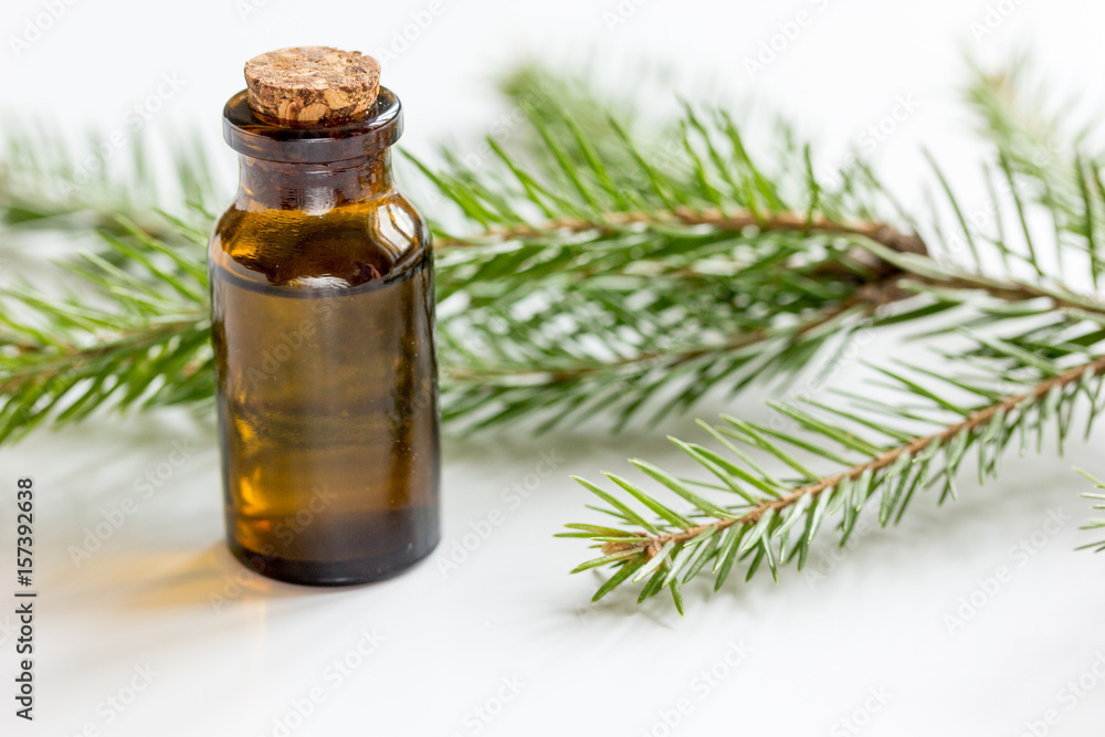 aromatherapy with organic spruce oils in glass bottles on white table background aromatherapy with organic spruce oils in glass bottles on white table background