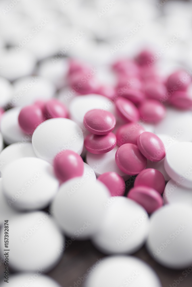Many white and pink tablets close-up