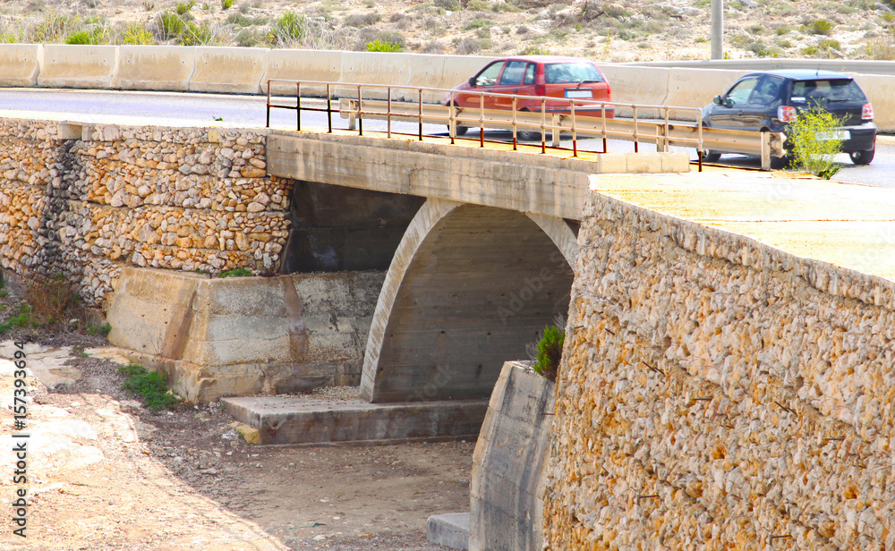 Mountain highway with concrete arch bridge for the passage of water Mountain highway with concrete arch bridge for the passage of water