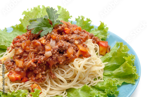 Spaghetti meat sauce ready to serve on blue plate on white background isolated