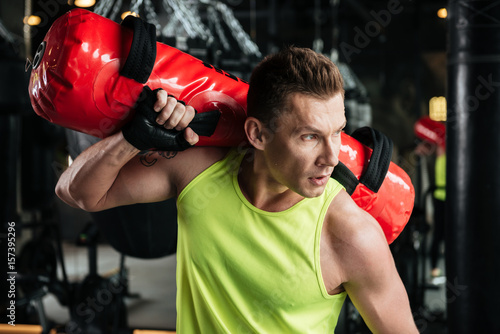 Sportsman holding punching bag on his shoulder in gym © Drobot Dean