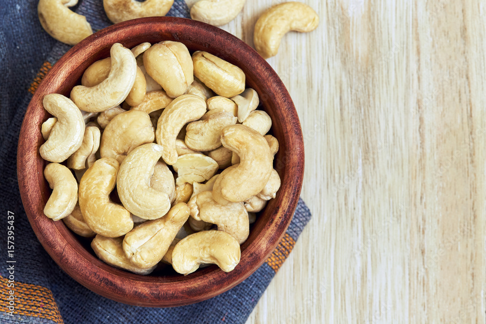 Cashew nuts in wooden bowl. Top view with copy space Cashew nuts in wooden bowl. Top view with copy space