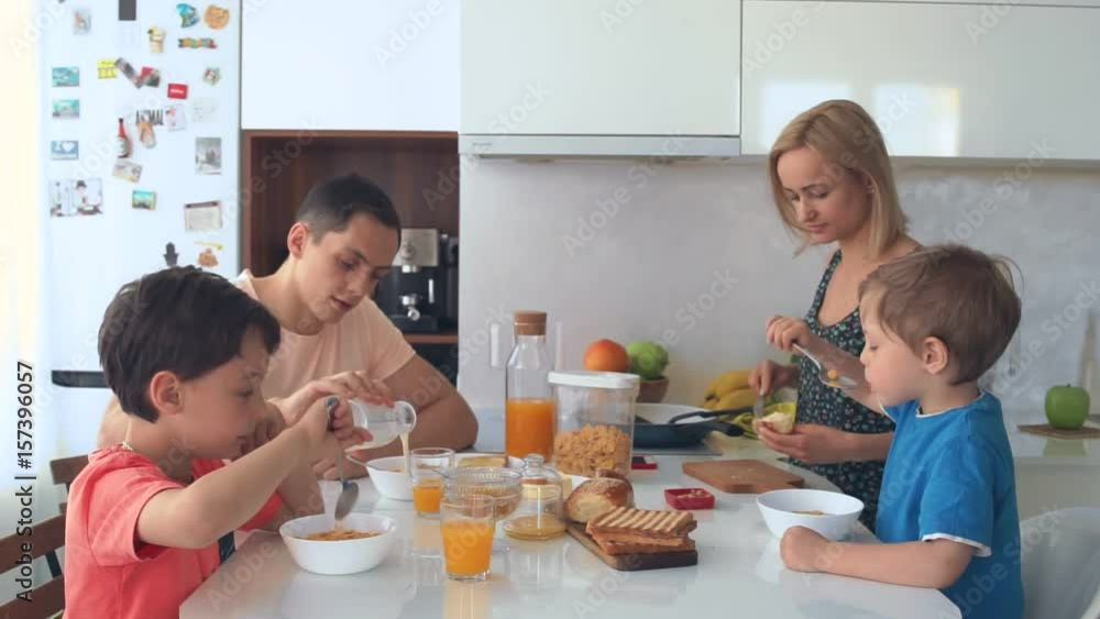 a young family with children having Breakfast in the bright kitchen