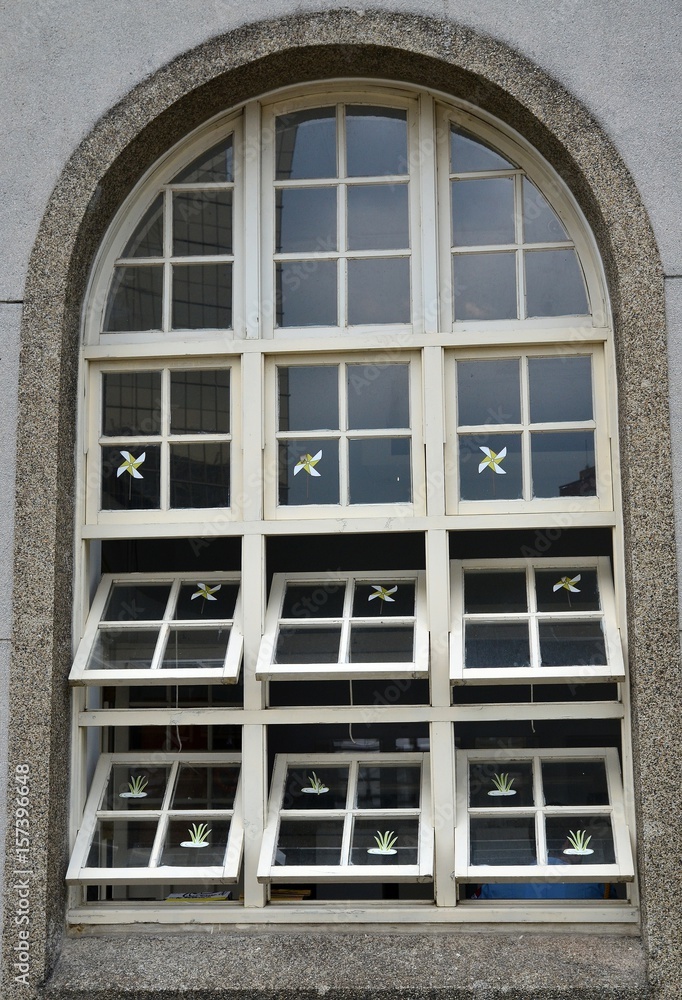 A wooden window there are some pinwheel patterns and paper herb patterns on it.