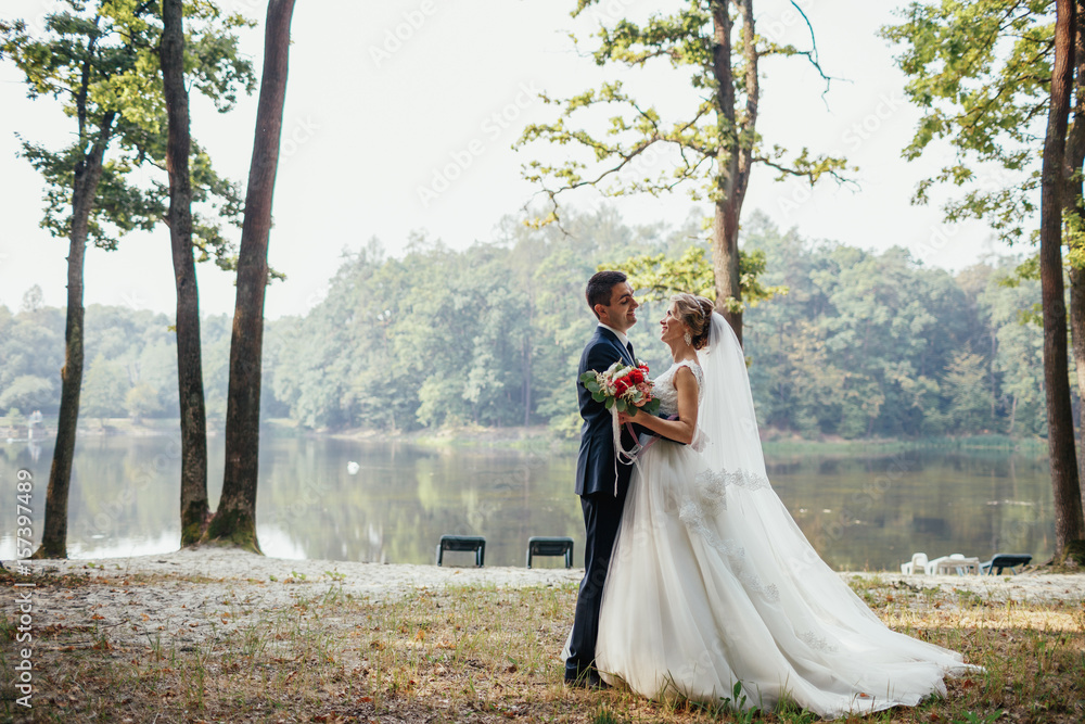 Tender hugs of newlyweds on the lake shore Tender hugs of newlyweds on the lake shore