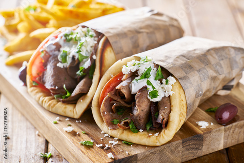 greek lamb meat gyros with tzatziki sauce, feta cheese and french fries