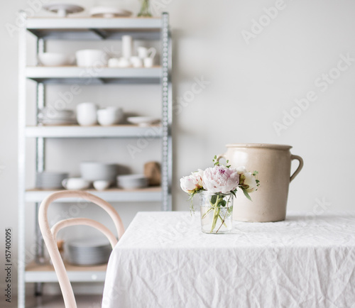Helles Esszimmer mit Regal in dem Geschirr steht photo