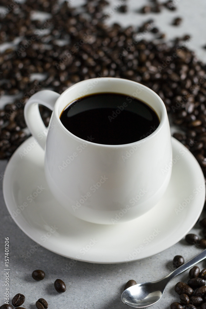 White glass of coffee with coffee bean on a stone table. White glass of coffee with coffee bean on a stone table.