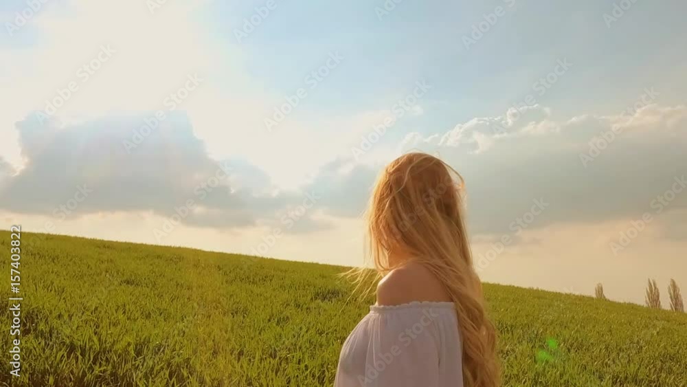 Happy woman with long hair on summer green field at sunset freedom concept Happy woman with long hair on summer green field at sunset freedom concept
