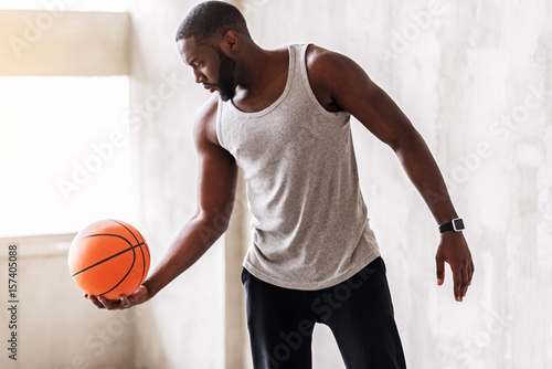 Confident athletic man with beard performing exercises with ball