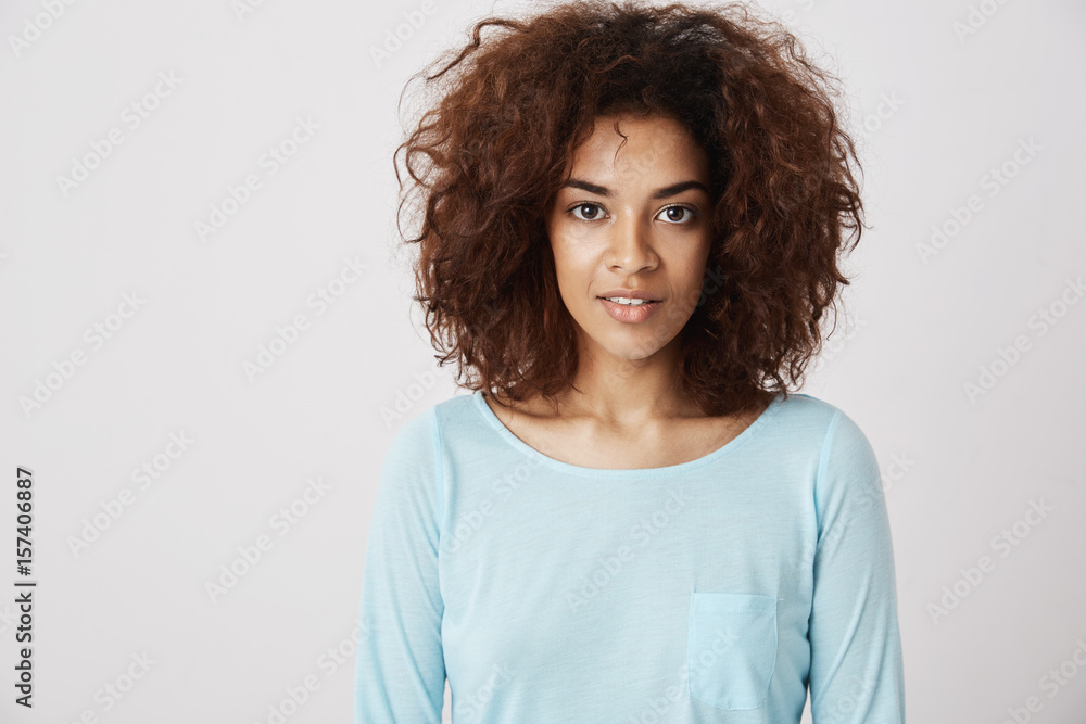 Portrait of beautiful african girl smiling looking at camera. White background. Portrait of beautiful african girl smiling looking at camera. White background.
