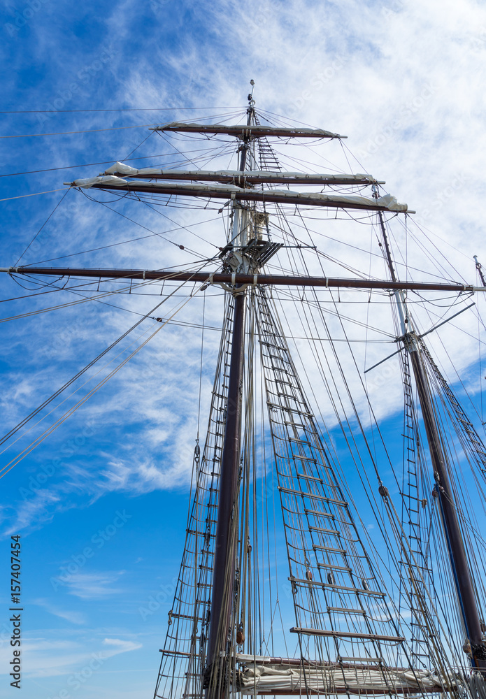 hoher segelmast mit takelage von unten vor blauem himmel