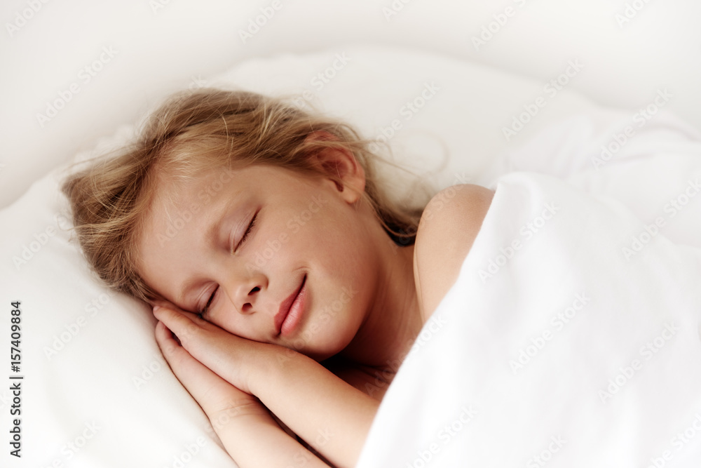 Adorable little girl sleeping in comfortable white bed in the room. Child healthy dream. Adorable little girl sleeping in comfortable white bed in the room. Child healthy dream.