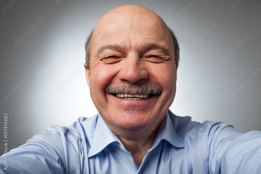 Elderly man laughs from ear to ear, giggles on the funny stories. Be happy of news or events Elderly man laughs from ear to ear, giggles on the funny stories. Be happy of news or events