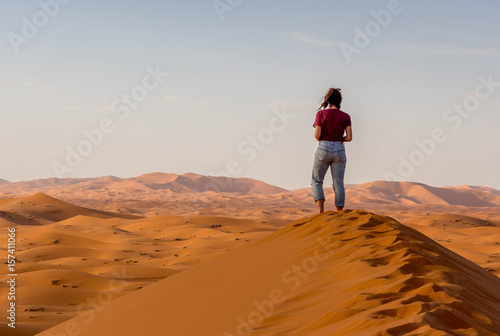 Frau sieht in die Weiten der Sahara Wüste